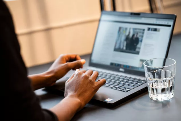 An open laptop with hands on the keyboard. Photographer Johan Persson.